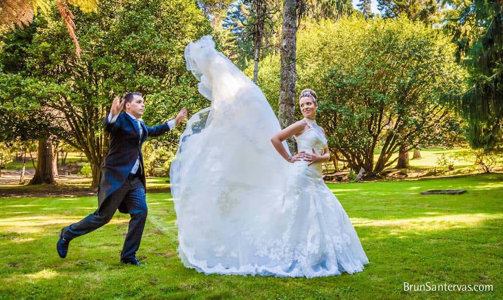 Novio colocando el vestido a la novia para la foto.